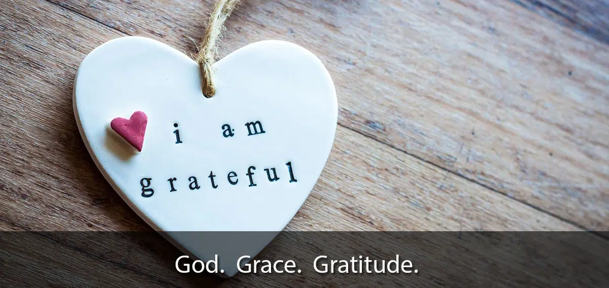Heart pendant saying i am grateful on wooden background